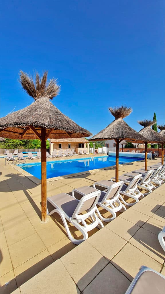 Relaxation area by the pool at La Pinède campsite in Verdon