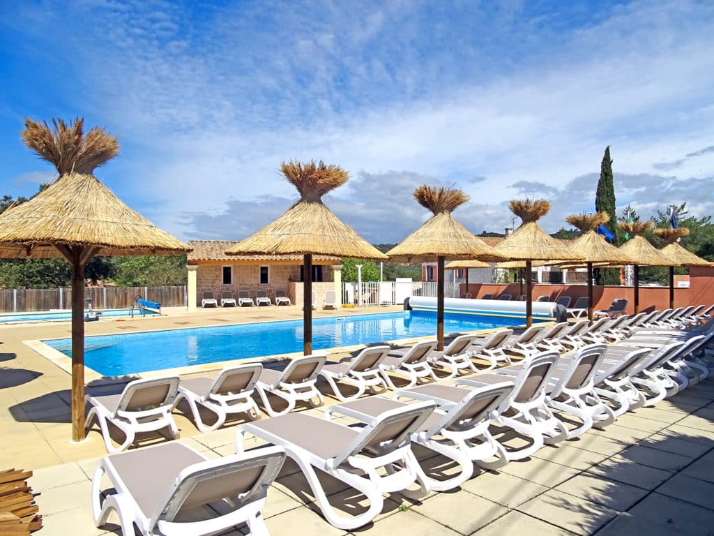 Liegestühle zum Ausruhen am Wasserbereich des Campingplatzes La Pinède in Gréoux-les-Bains