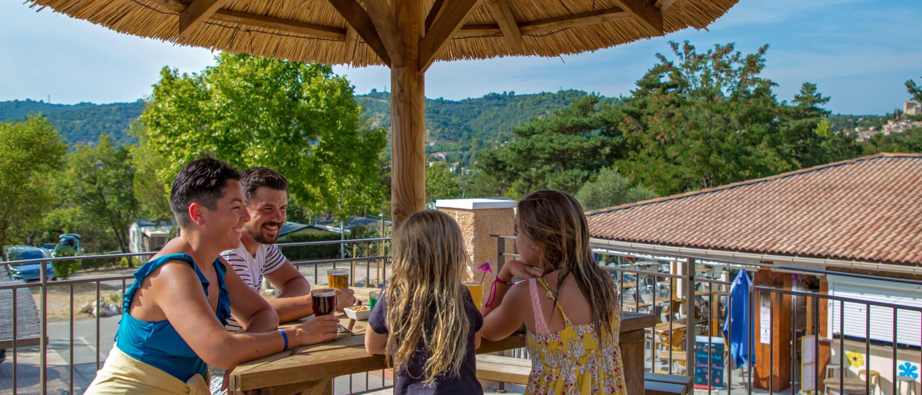 famille sous en parasole pour se rafraichir en boisson